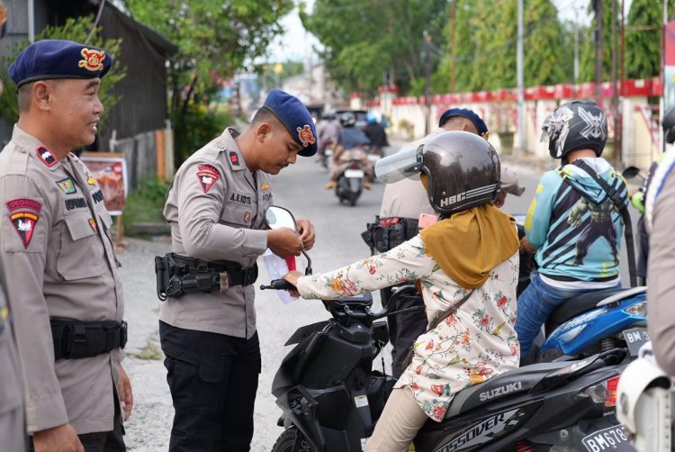 Tunjukkan Rasa Nasionalisme, Brimob Polda Riau Bagikan Bendera Merah Putih ke Masyarakat